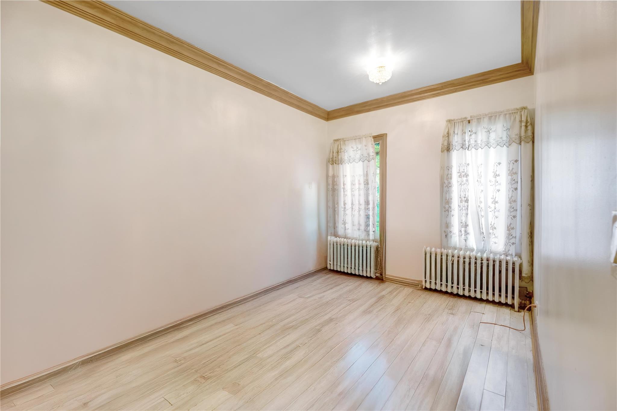 1520 Lincoln Place Brooklyn, NY 11213 - Photo 5 of 7 an empty room with wooden floor and windows