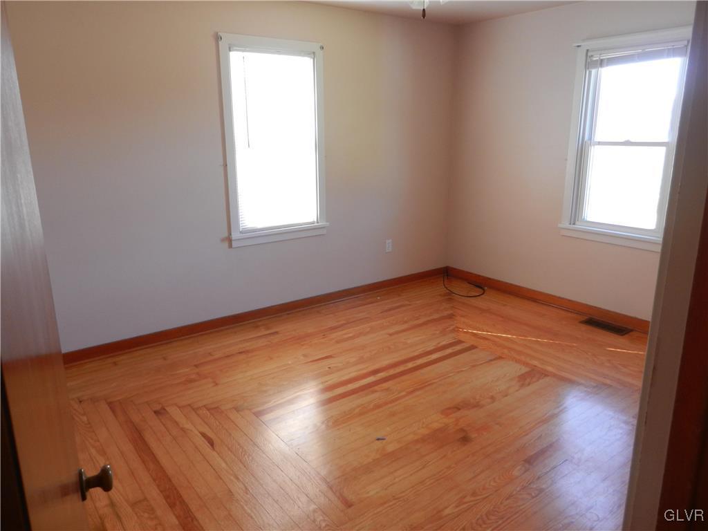 5027 Huckleberry Road Orefield, PA 18069 - Photo 11 of 17 an empty room with wooden floor and windows