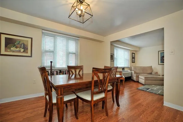 a dining room with furniture a chandelier and wooden floor