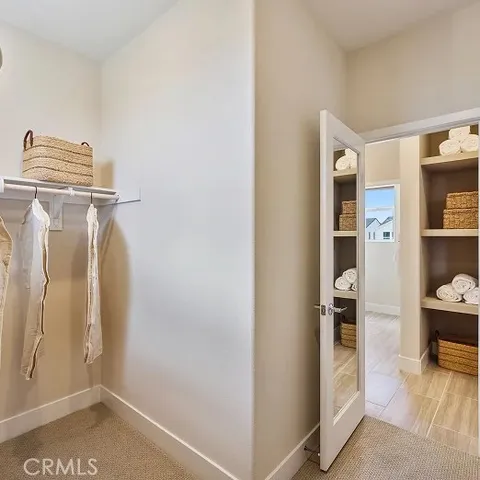 a view of walk in closet with clothes and shoes