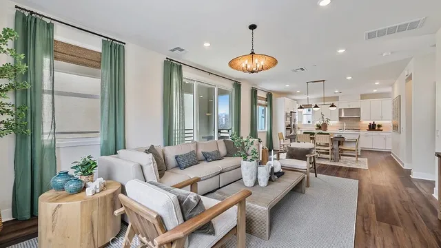 a living room with furniture kitchen and a large window