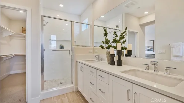 a bathroom with a double vanity sink mirror and shower