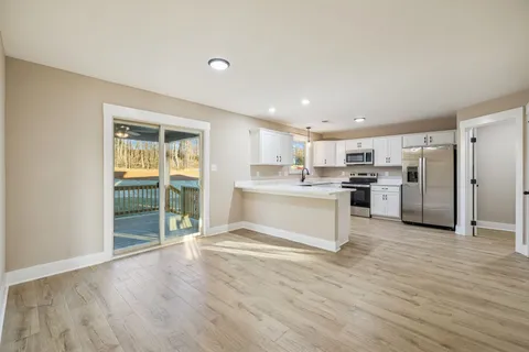 a view of kitchen with wooden floor and electronic appliances