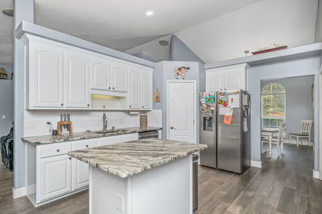 a kitchen with granite countertop a sink appliances and cabinets
