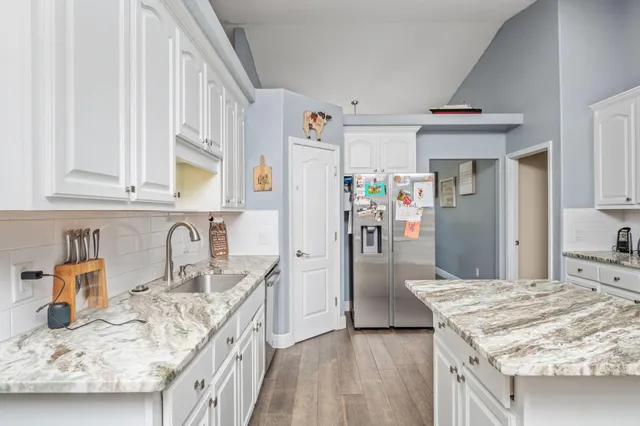 a kitchen with granite countertop a sink stove and refrigerator