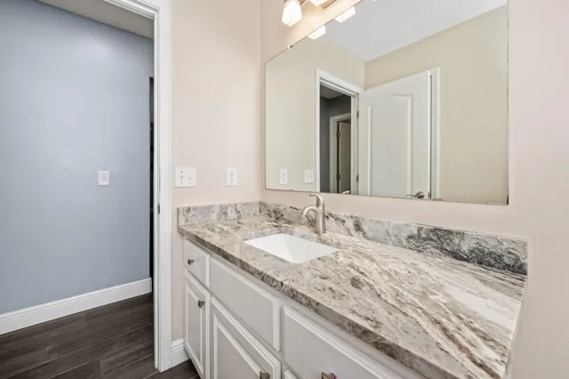 a bathroom with a granite countertop sink and a mirror