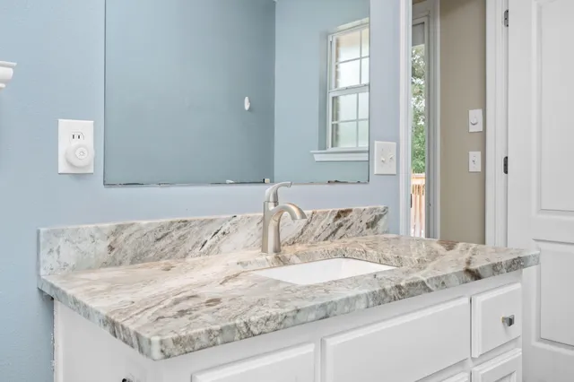 a bathroom with a granite countertop sink and mirror