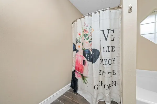 a white curtain with a white comforter and a window