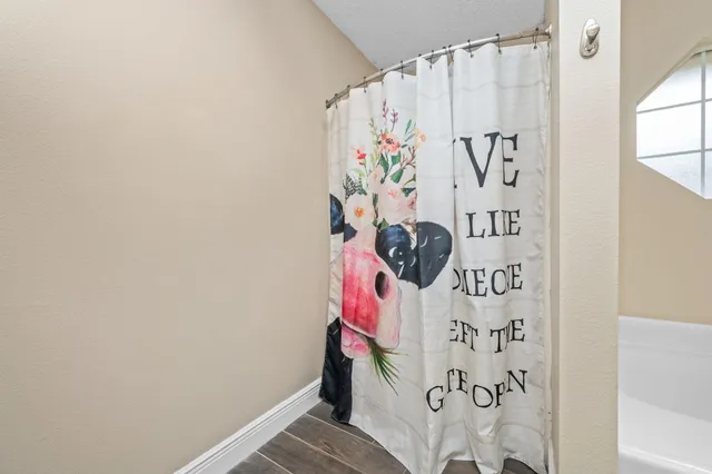 a white curtain with a white comforter and a window