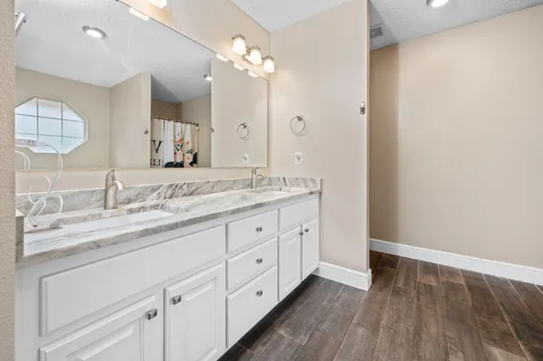 a bathroom with a granite countertop sink mirror and cabinets