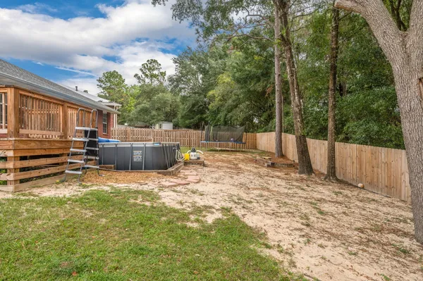 a backyard of a house with barbeque oven and trees