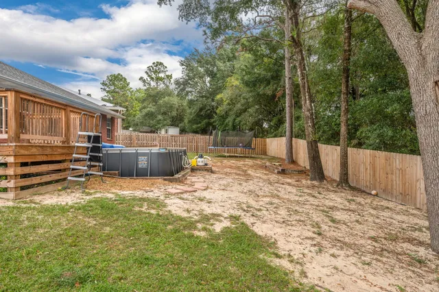 a backyard of a house with barbeque oven and trees