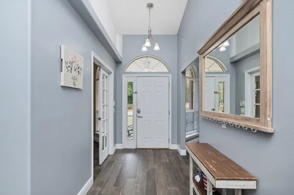 a view of a hallway with entryway wooden floor and front door