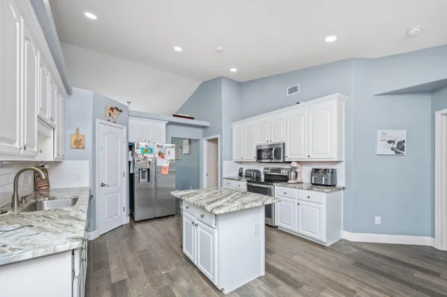a kitchen with stainless steel appliances granite countertop a sink stove and refrigerator
