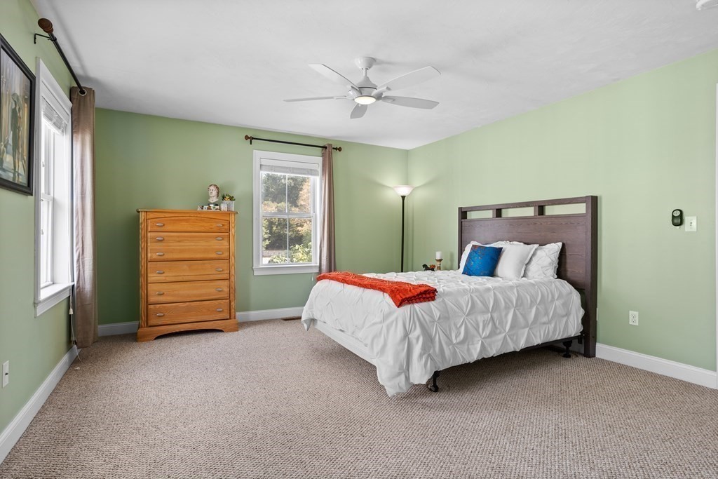 8 High Street, Unit D2 Acton, MA 01720 - Photo 17 of 35 a spacious bedroom with a bed a dresser and a window