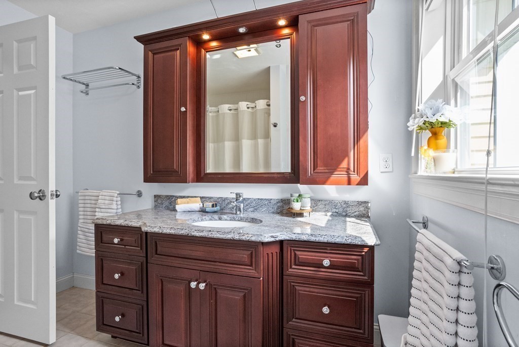 8 High Street, Unit D2 Acton, MA 01720 - Photo 21 of 35 a bathroom with a granite countertop sink and a mirror