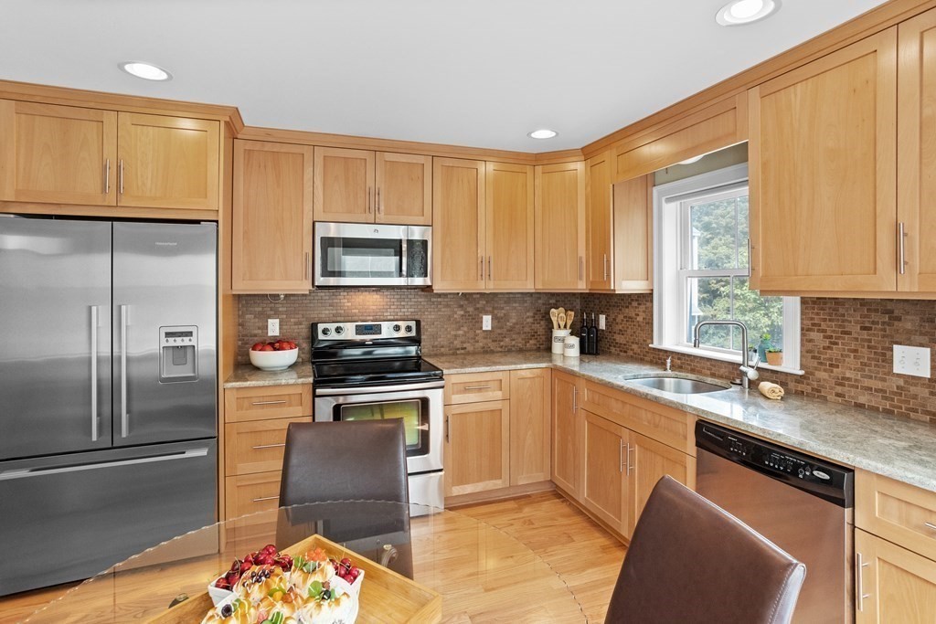 8 High Street, Unit D2 Acton, MA 01720 - Photo 9 of 35 a kitchen with stainless steel appliances granite countertop a stove a sink a microwave a refrigerator and cabinets