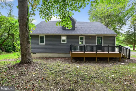 a backyard of a house with wooden fence and a tree