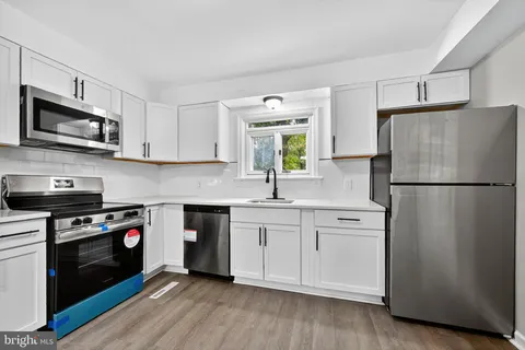 a kitchen with stainless steel appliances a refrigerator sink and microwave
