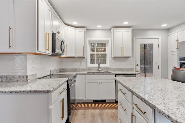 a kitchen with stainless steel appliances granite countertop a sink stove and cabinets
