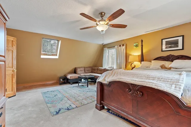 a spacious bedroom with a bed a couch and a dresser