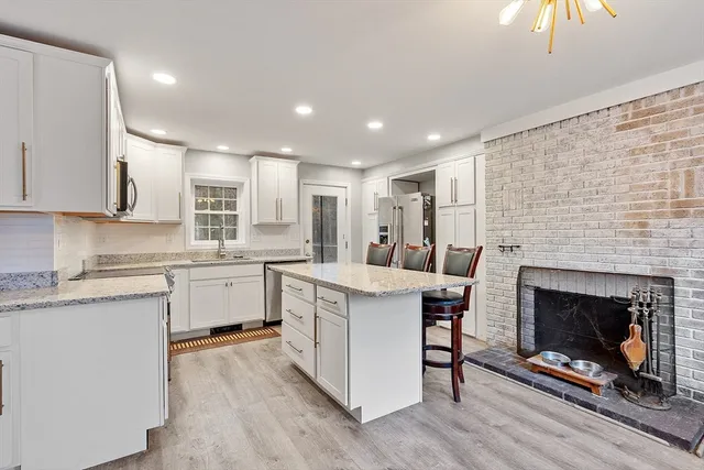 a kitchen with a stove a sink and a fireplace