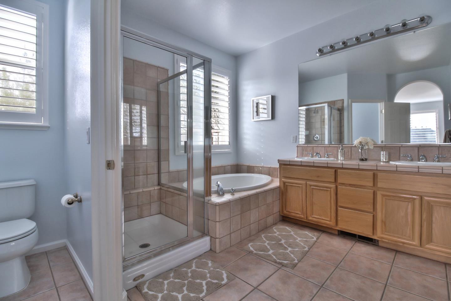 897 Skyridge Drive Pacifica, CA 94044 - Photo 21 of 37 a bathroom with a granite countertop sink a toilet a mirror and shower