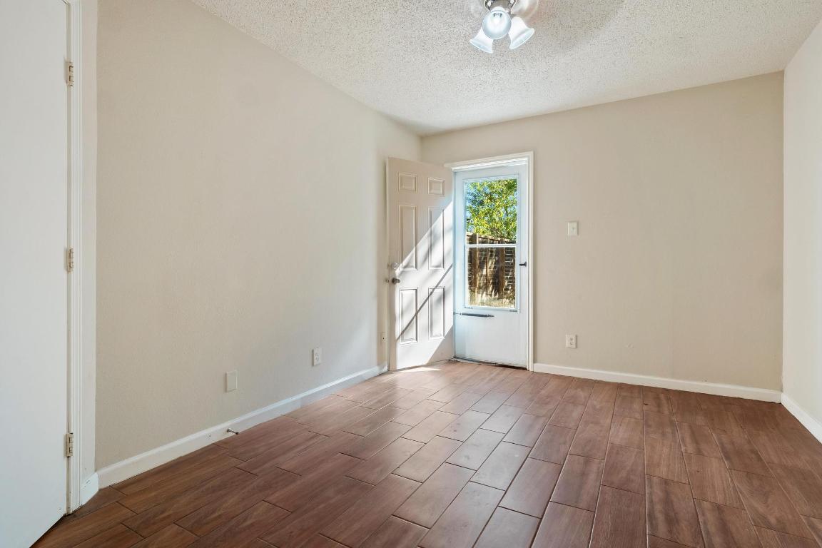 1115 Brookswood Avenue, Unit B Austin, TX 78721 - Photo 21 of 34 a view of an empty room with a window and hardwood floor