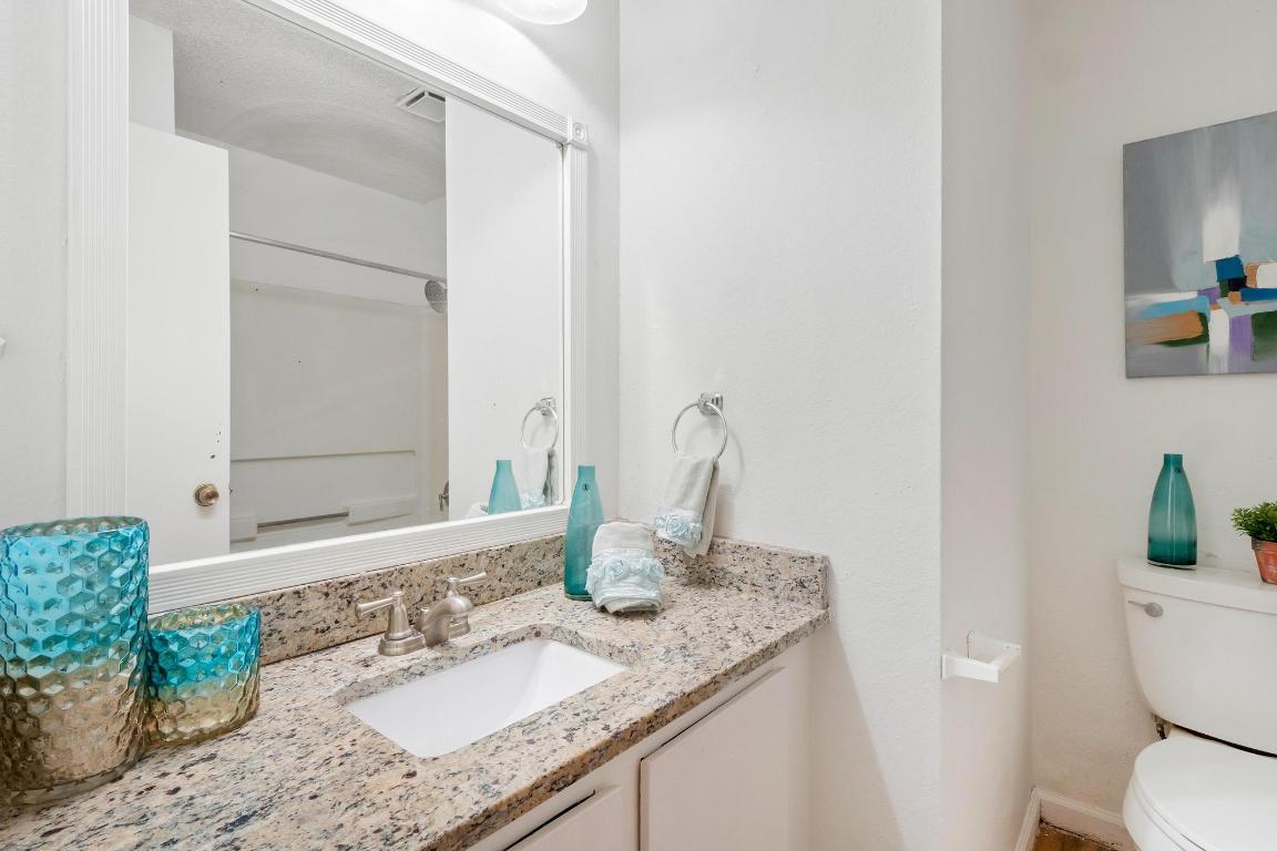 1115 Brookswood Avenue, Unit B Austin, TX 78721 - Photo 24 of 34 a bathroom with a granite countertop sink and a mirror