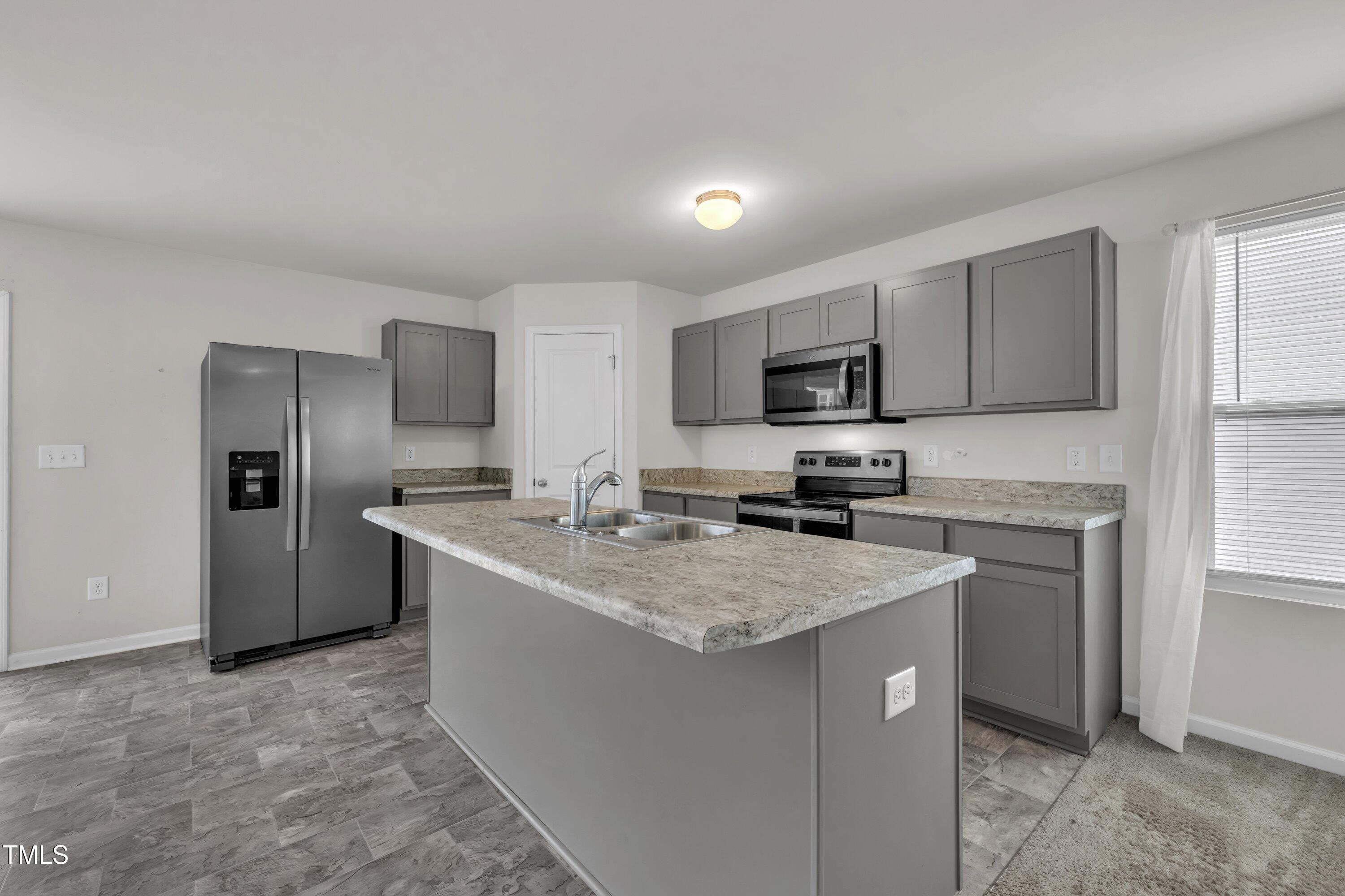 146 Maple Tree Lane Clayton, NC 27527 - Photo 20 of 50 a kitchen with a sink stove a refrigerator and a microwave