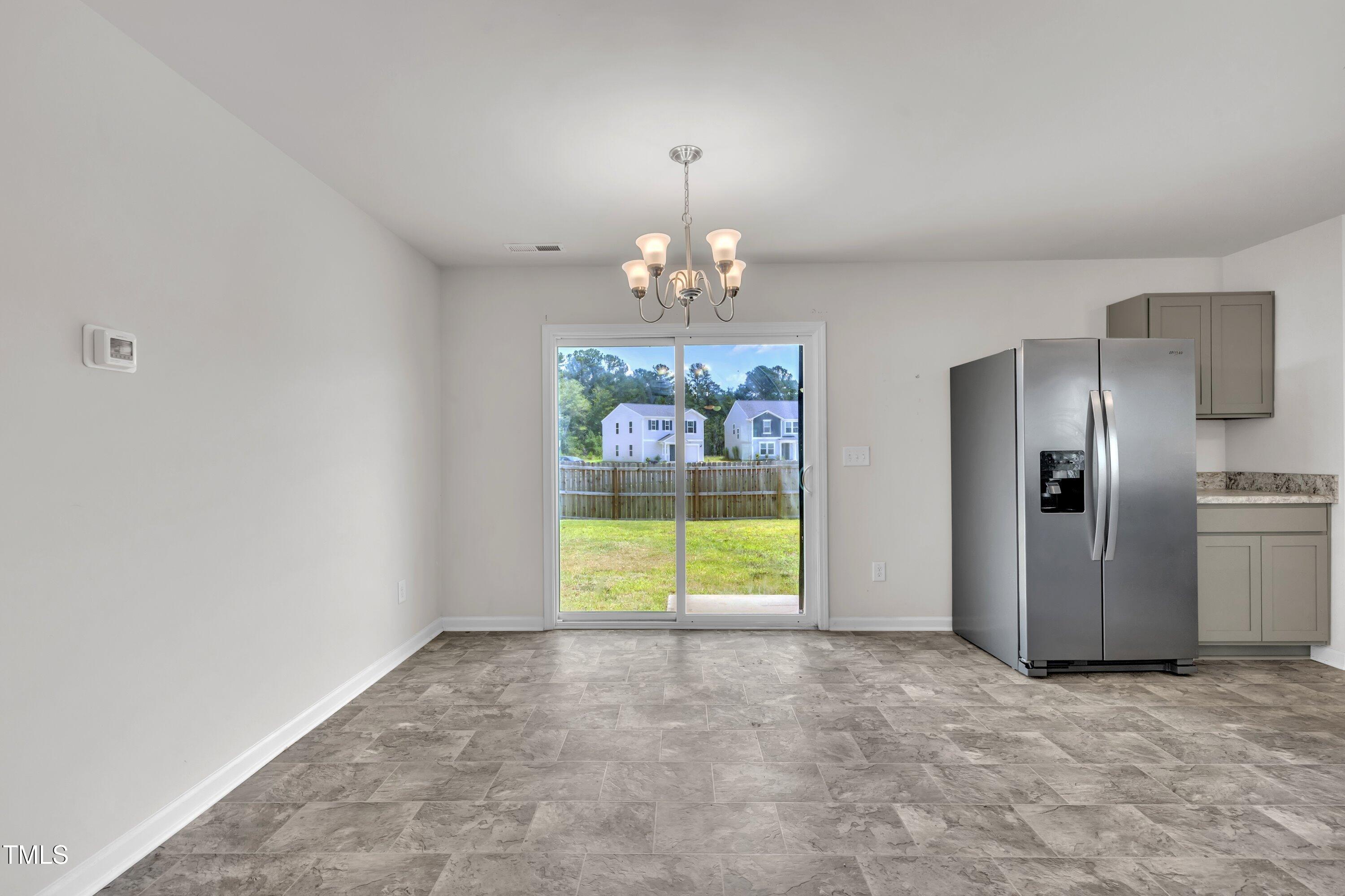 146 Maple Tree Lane Clayton, NC 27527 - Photo 21 of 50 an empty room with chandelier and windows