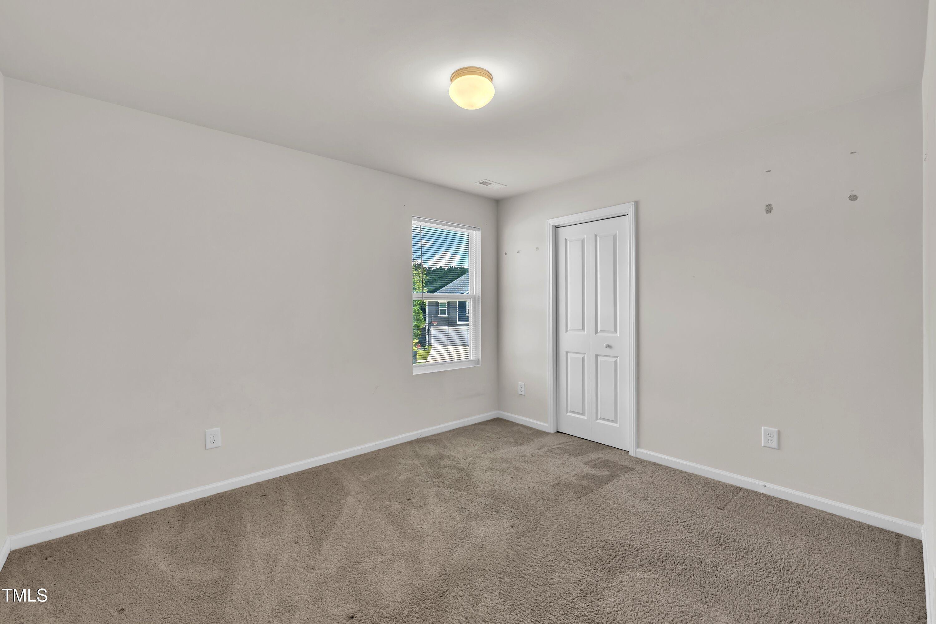 146 Maple Tree Lane Clayton, NC 27527 - Photo 31 of 50 an empty room with windows and mirror