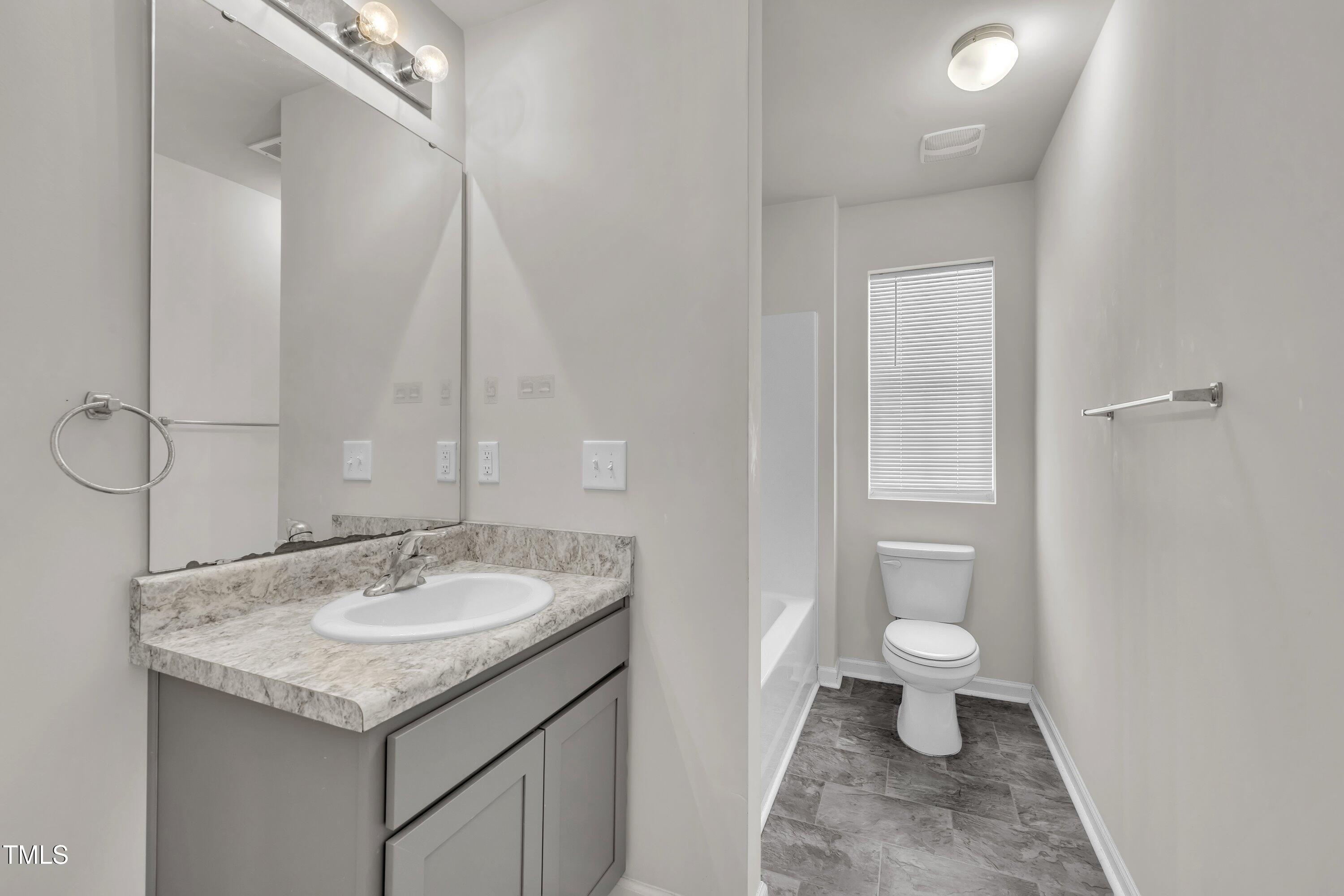 146 Maple Tree Lane Clayton, NC 27527 - Photo 43 of 50 a bathroom with a granite countertop sink and a mirror
