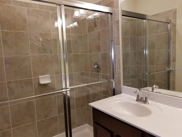a bathroom with a sink mirror and a shower
