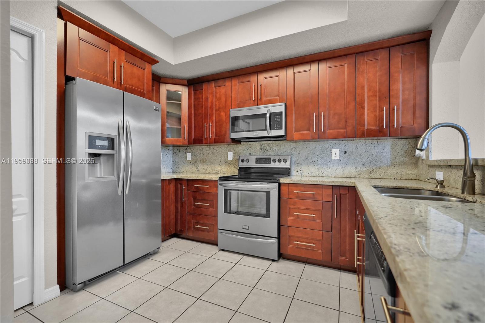 8964 West Flagler Street, Unit 109 Miami, FL 33174 - Photo 14 of 39 a kitchen with stainless steel appliances granite countertop a refrigerator stove and sink