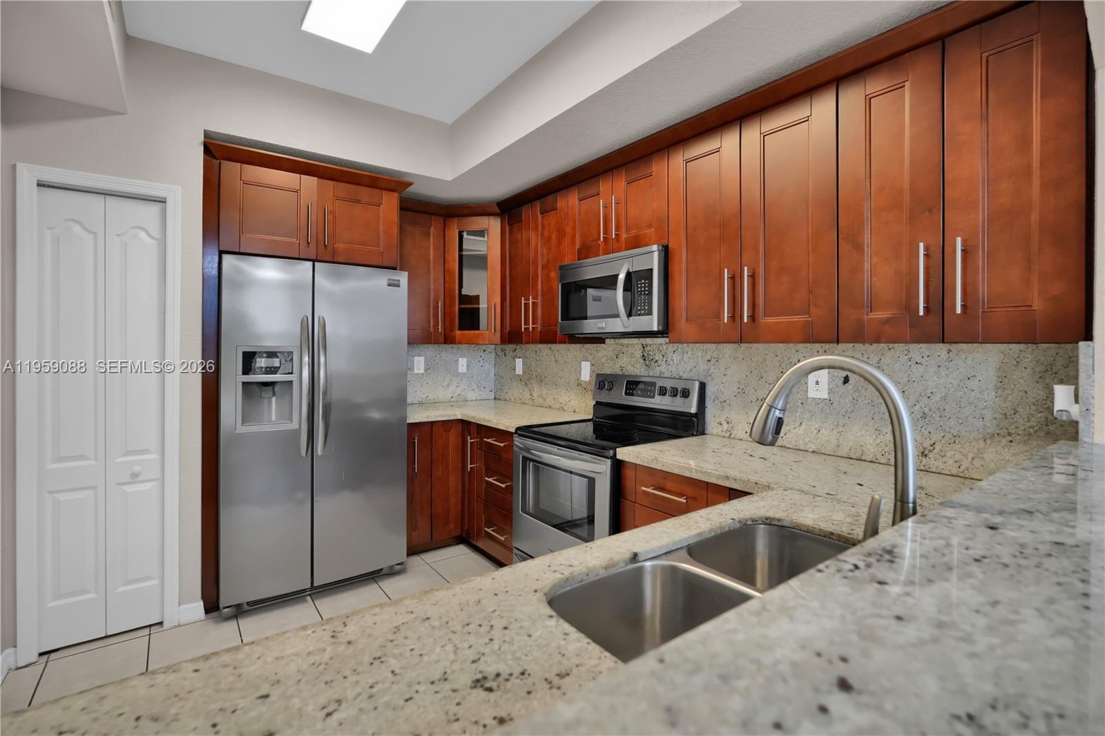 8964 West Flagler Street, Unit 109 Miami, FL 33174 - Photo 15 of 39 a kitchen with stainless steel appliances granite countertop a refrigerator a stove top oven a sink and dishwasher