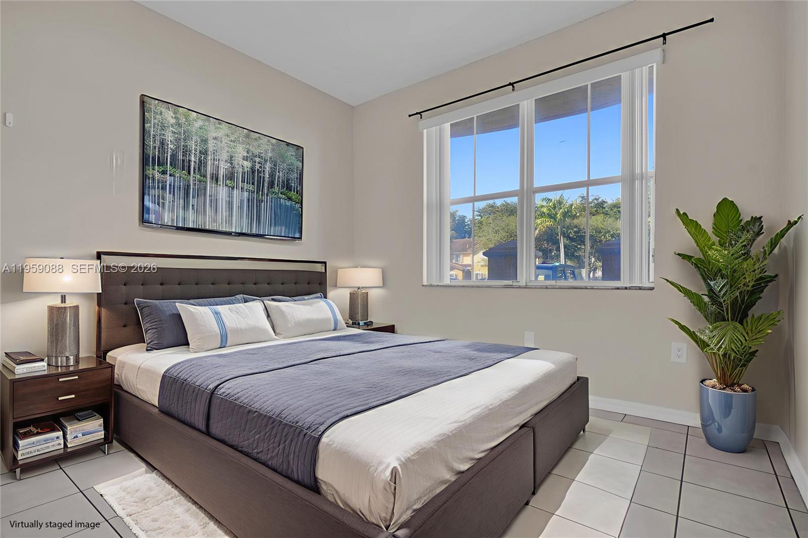 8964 West Flagler Street, Unit 109 Miami, FL 33174 - Photo 24 of 39 a bedroom with a large bed and a potted plant