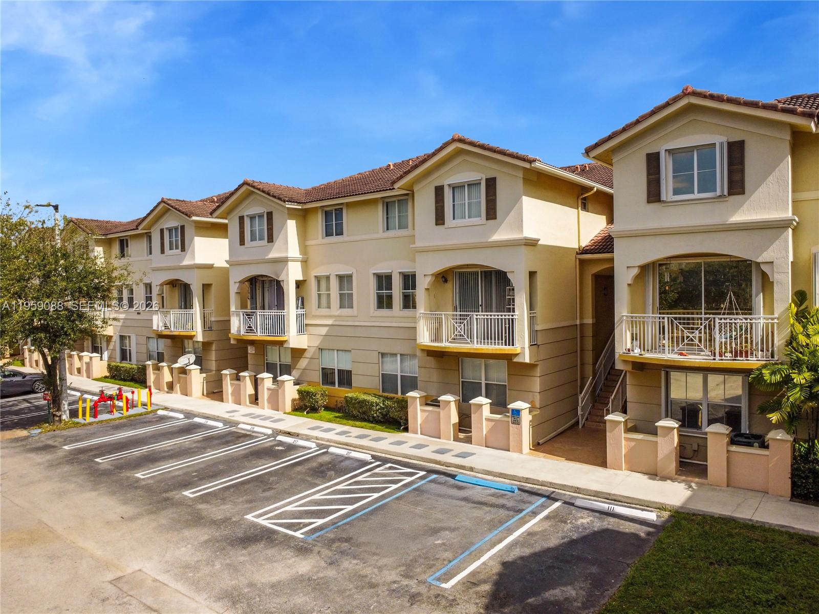 8964 West Flagler Street, Unit 109 Miami, FL 33174 - Photo 31 of 39 a front view of a residential apartment building with a yard