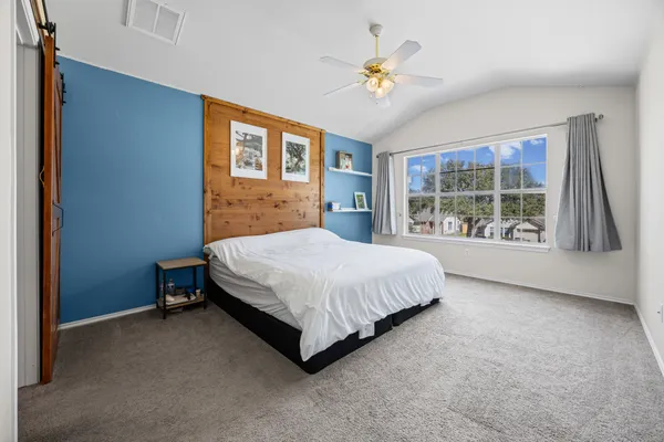 a spacious bedroom with a bed and a window