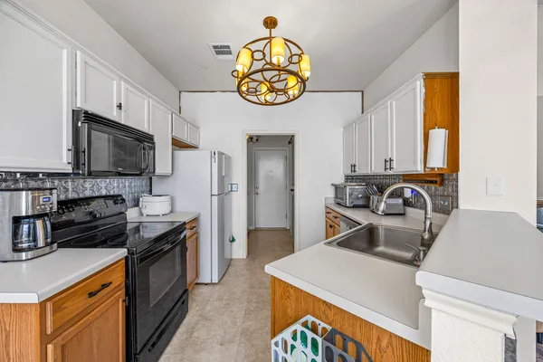 a kitchen with kitchen island granite countertop a stove and a sink