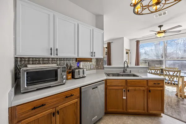 a kitchen with stainless steel appliances granite countertop a stove a sink and a microwave