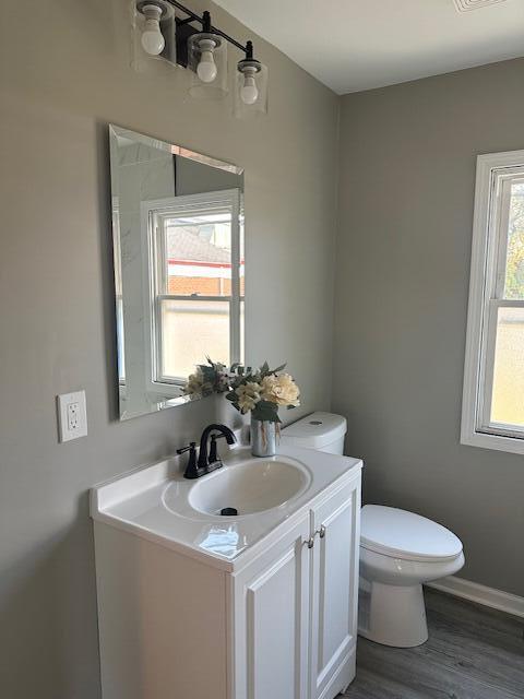 8322 Harrison Avenue Munster, IN 46321 - Photo 5 of 6 a bathroom with a toilet a sink a mirror and a window