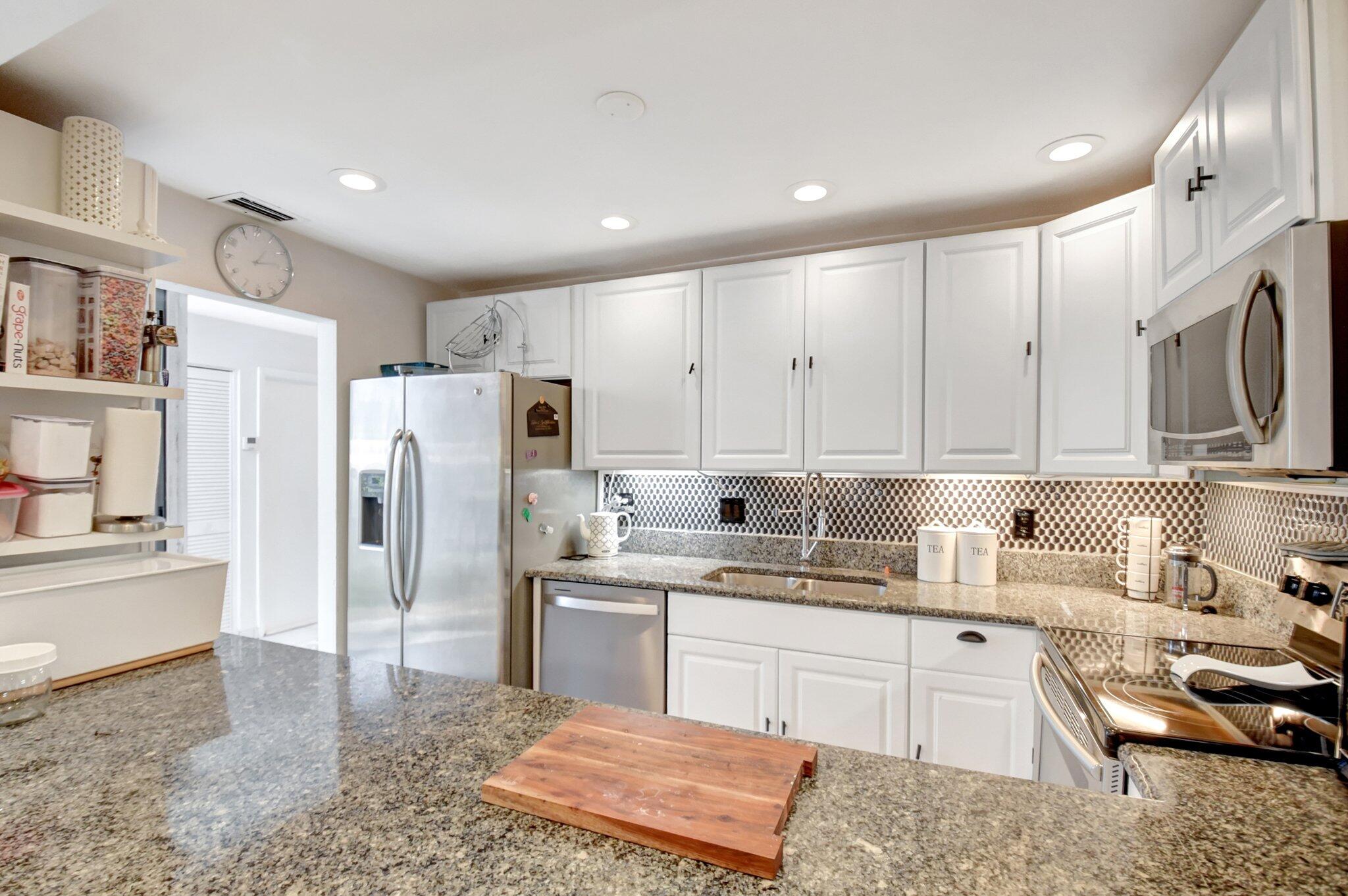 11067 Oakdale Road Boynton Beach, FL 33437 - Photo 14 of 31 a kitchen with a sink a refrigerator and cabinets