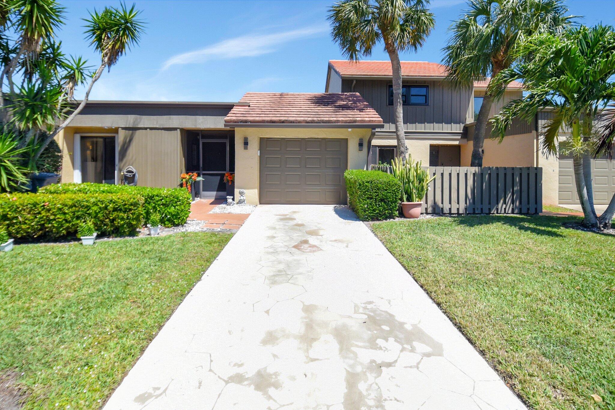 11067 Oakdale Road Boynton Beach, FL 33437 - Photo 2 of 31 a front view of a house with a yard and potted plants