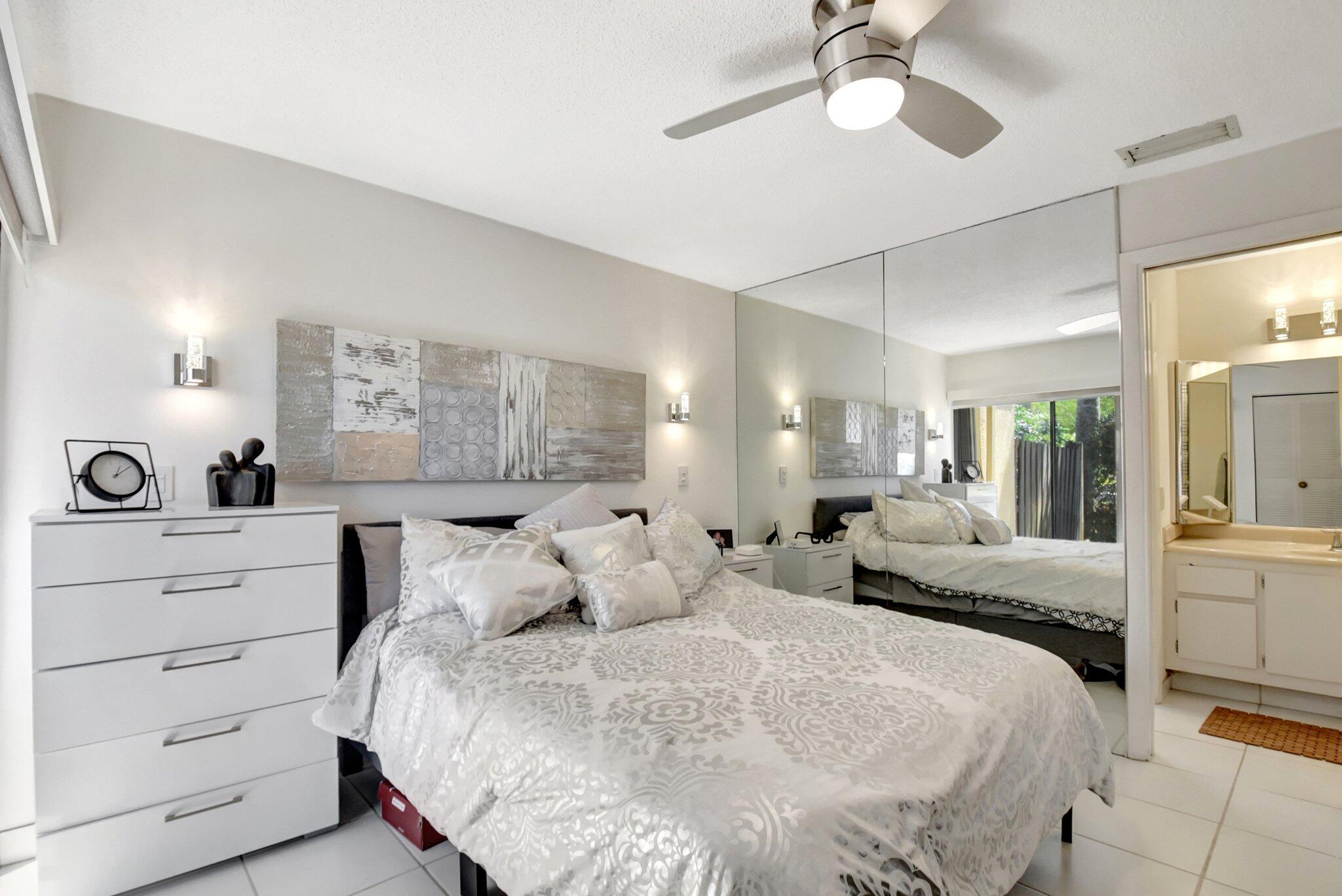 11067 Oakdale Road Boynton Beach, FL 33437 - Photo 21 of 31 a large bedroom with a bed and ceiling fan
