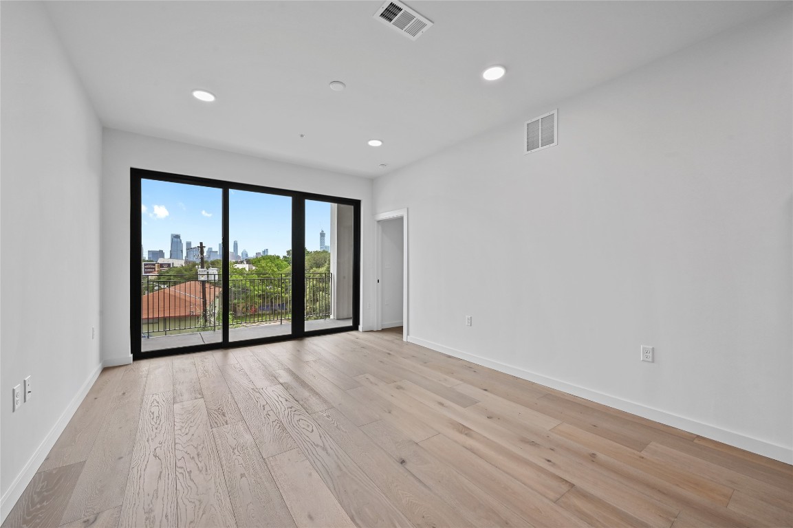 2209 South 1st Street, Unit 209 Austin, TX 78704 - Photo 3 of 33 a view of an empty room with wooden floor and a window