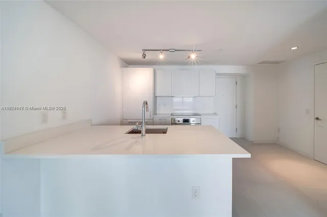 a view of a kitchen with a sink and chandelier