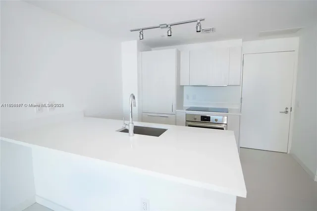 a kitchen with a sink and a refrigerator