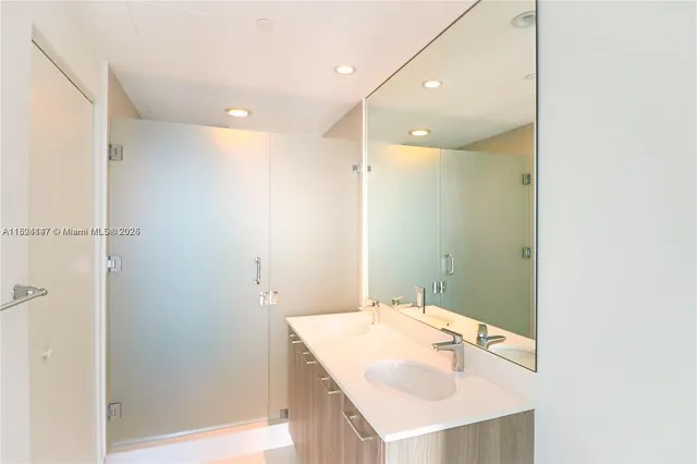 a bathroom with a sink a shower and a mirror