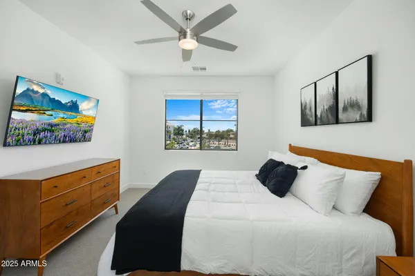 a bedroom with a bed and a painting on the wall